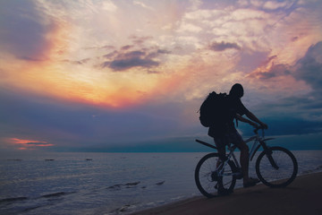 Mountain biker on beach and sunset