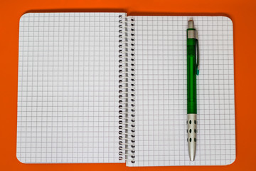 Spiral Notebook with green Pen.
