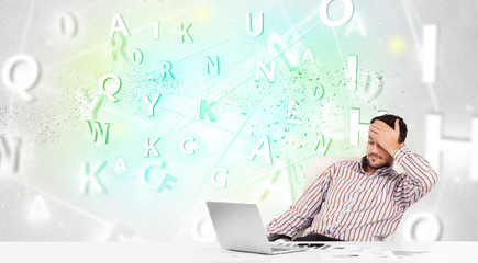 Business man at desk with green word cloud