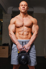 Strong muscular man bodybuilder shows his muscles.