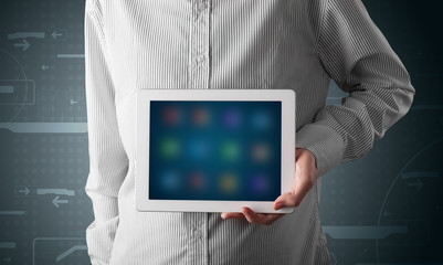 Businessman holding a white modern tablet with blurry apps