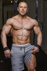 Fototapeta na wymiar Strong muscular man bodybuilder poses.