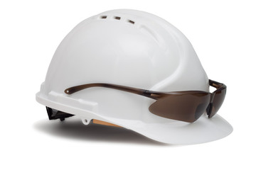 Construction helmet and safety glasses on white background
