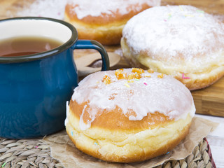 Classic glazed doughnuts and mug of tea