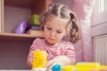 little cute girl playing in her playroom