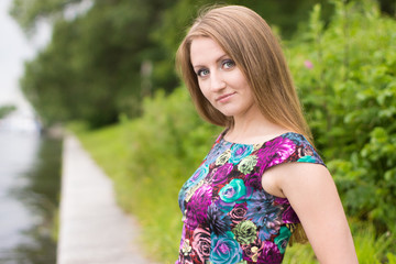 Fototapeta premium portrait of a beautiful girl on a background of the river