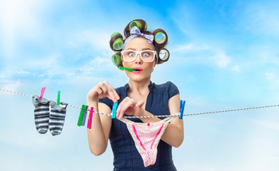 Woman hanging wet clothing with clothespin