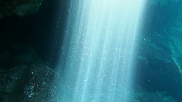 Sunbeams shining in an underwater cave