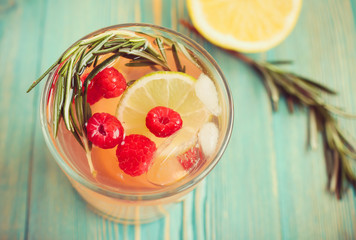 detox water in cup with raspberry, rosemary and citrus, close-up