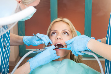 Dentist drilling tooth of young women