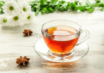 Glass cup of tea on a wooden table.