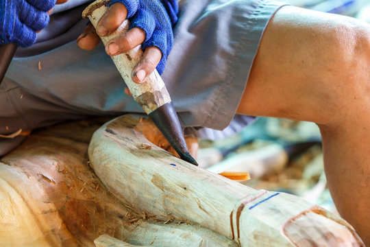 Hand of carver carving wood