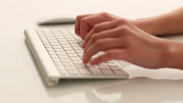 Woman's hands typing on a computer keyboard