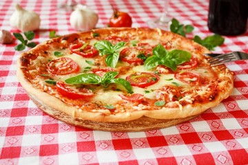 Pizza Margherita mit Tomaten, Basilikum, Majoran und Mozzarella