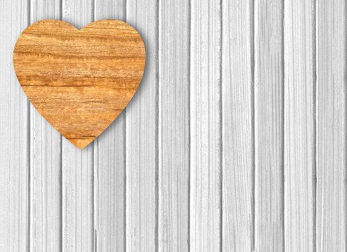 wooden heart on white wooden background