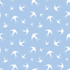 Seamless pattern with white swallows on blue. Vector.