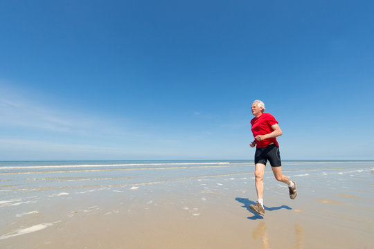 Elder Man Running At The Beach