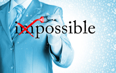 Businessman Hand turning the word Impossible into Possible with