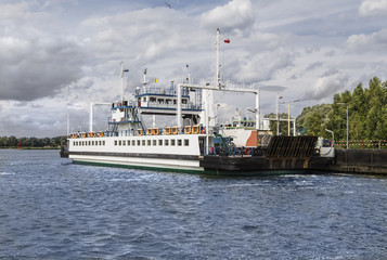 Fototapeta premium Ferry with cars floating across the river