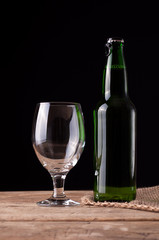 Glass and bottle with beer on wooden table