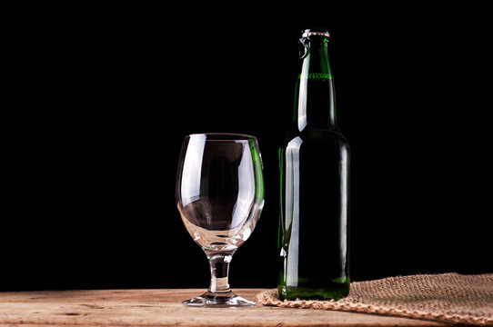 Glass and bottle with beer on wooden table