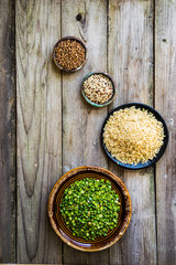 Peas,brown rice,quinoa and buckwheat on wooden background
