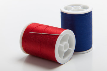 Red and blue spools of sewing thread