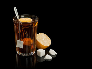 Tea in a thick glass tumbler with a lemon and sugar