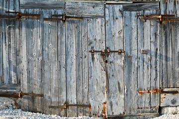 Portone vecchio in legno con chiavistello arrugginito