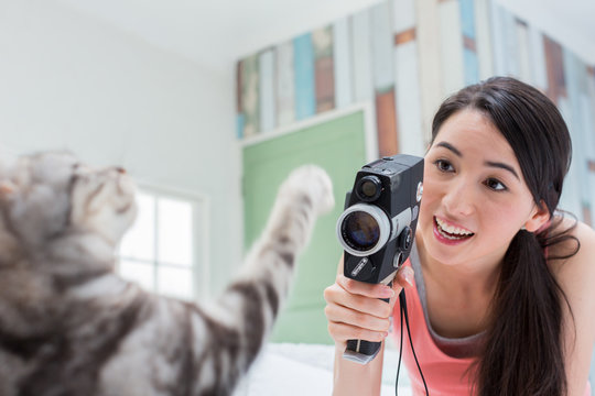 カメラ女子　カメラで猫を撮る女性