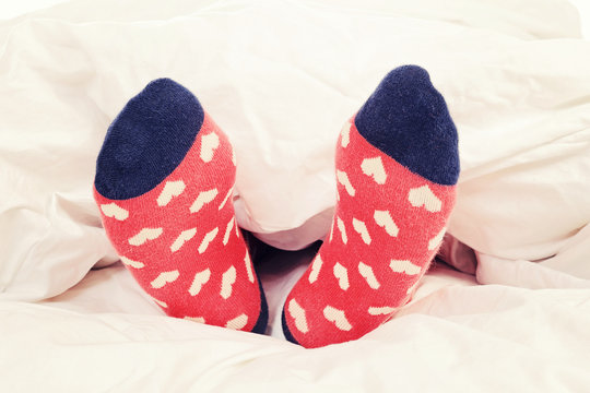 enfant dans lit avec chaussettes