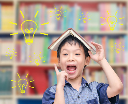 Young Asian boy thinking with light  bulbs in library