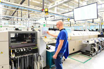Maschinen und Arbeiter in einer Fabrik für Mikroelektronik