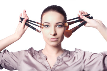 Obraz premium beautiful girl holding a set of professional makeup brushes.