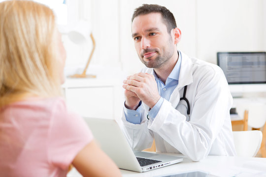 Young attractive doctor listening his patient