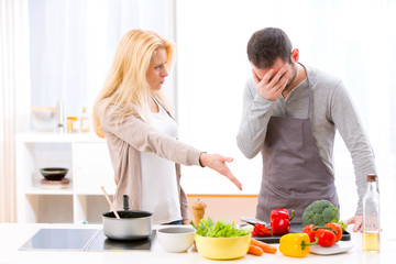 Young attractive couple having an argue while cooking