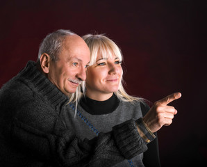 Senior man pointing at something to young woman