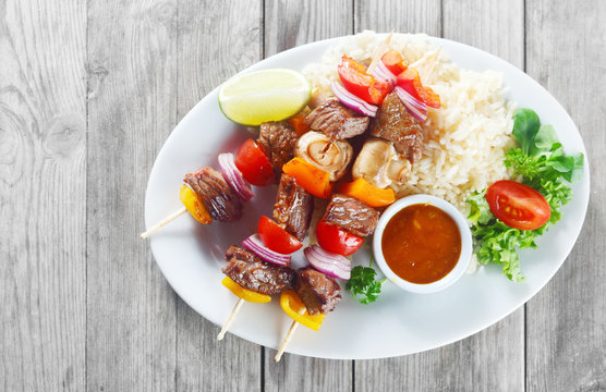 Gourmet Kebabs on Plate with Sauce and Rice