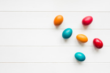 Easter eggs on white wooden background, top view
