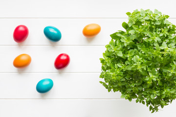 Top view of colourful easter eggs on white wooden background
