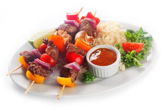 Tasty Kebabs on Plate with Rice, Sauce and Veggies