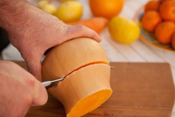 hand with a knife cuts the pumpkin