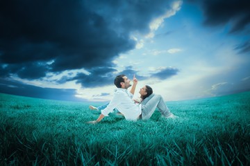 Naklejka na ściany i meble Composite image of attractive young couple lying down
