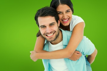 Fototapeta premium Happy casual man giving pretty girlfriend piggy back