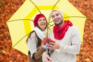 Composite image of autumn couple holding umbrella