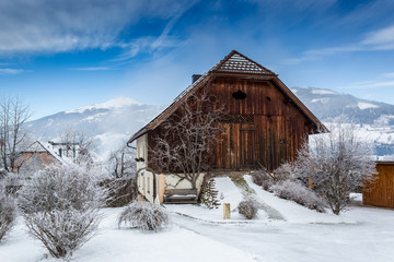 wooden barn covered by snow in Austrian Alps