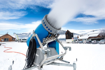snow cannon making artificial snow at cold on ski slope