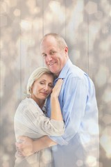 Composite image of happy mature couple hugging and smiling