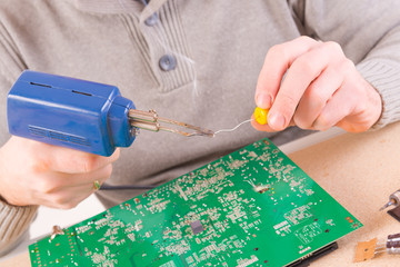 Serviceman soldering on PCB