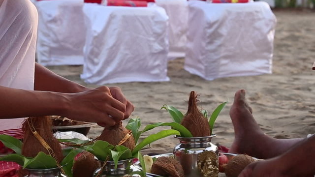 hindu brahmins in Indian wedding ceremony decorate coconuts with